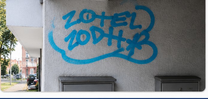 Blaues Graffiti auf gestrichener Fassade